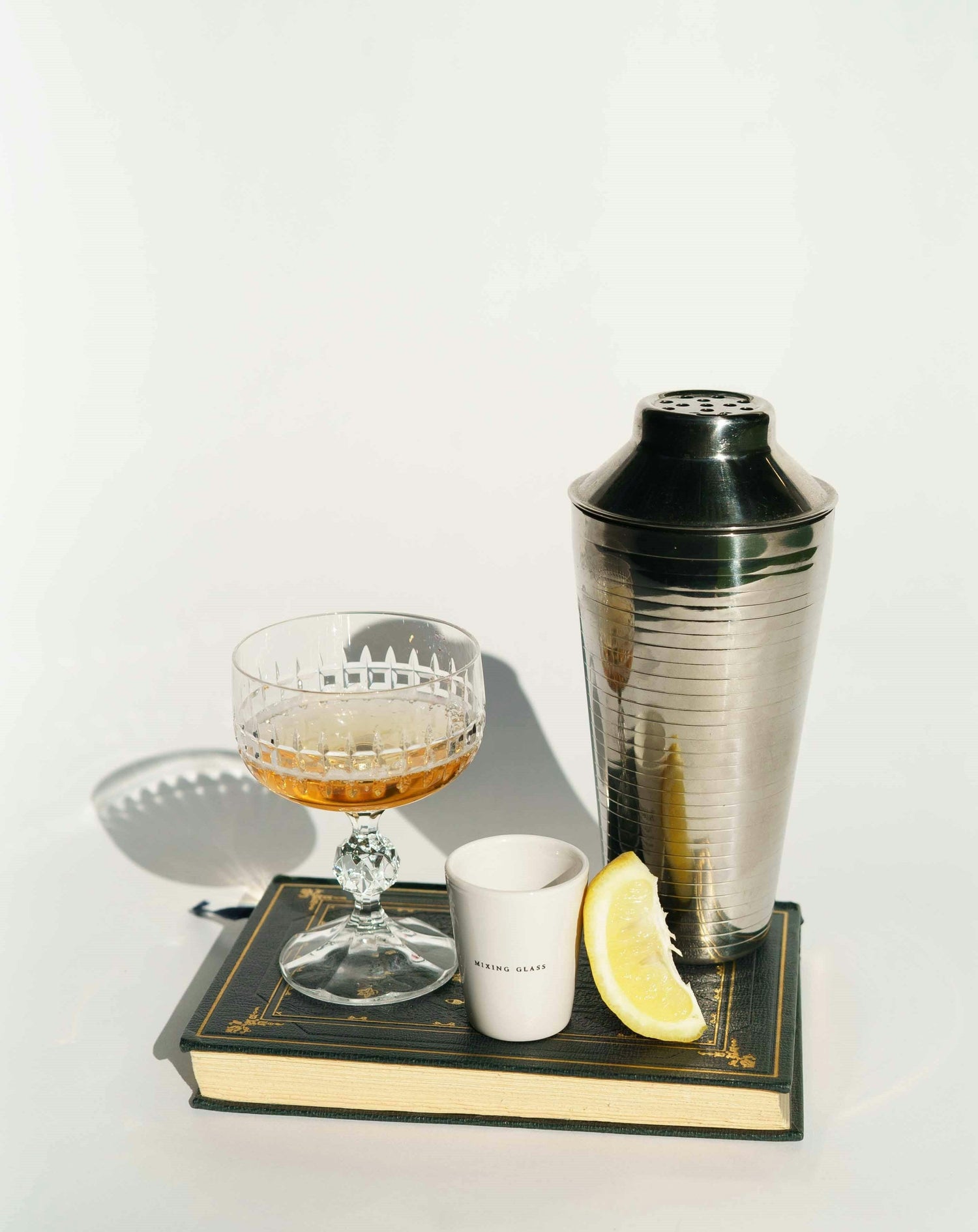 "An assortment of sleek, modern bar tools neatly arranged on a countertop, including shakers, strainers, jiggers, stirrers, and glasses, ready for crafting delicious cocktails.