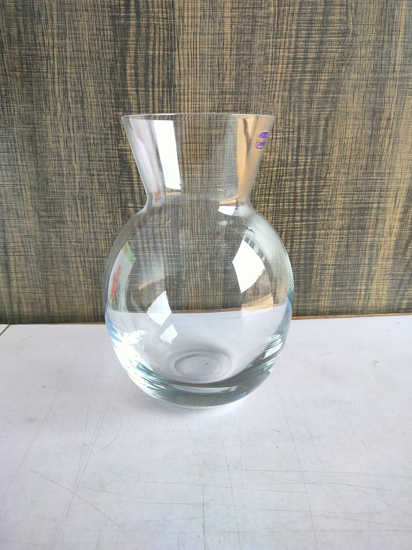 Side view of Florero Glass Vase on a wooden table.
