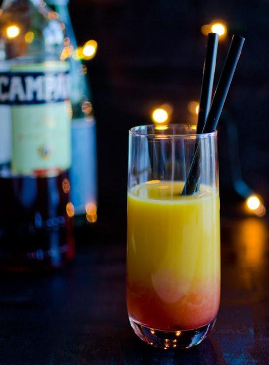 Kouros highball glass filled with a colorful cocktail, showcasing its tall design.