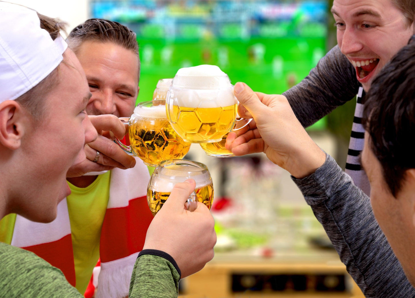 Friends toasting with Football Glass Beer Mugs.