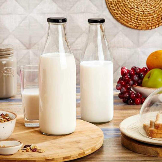Clear glass bottle with lid filled with fresh milk.