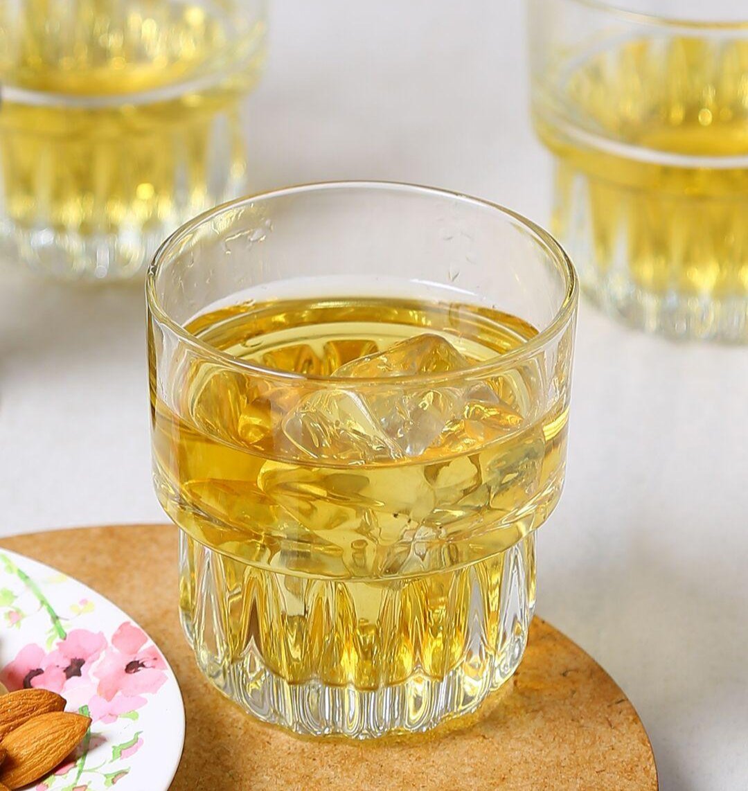 Unique hills pattern on a clear whiskey glass capturing light.
