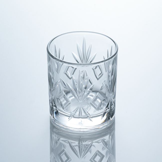 Close-up of the finely contoured rim and substantial base of the whiskey glass.