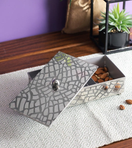 Grid Stainless Steel Nut Bowl with Lid on a coffee table.