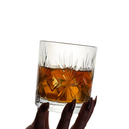 A hand holding the Crystal Whiskey Glass, ready for a refined sip.