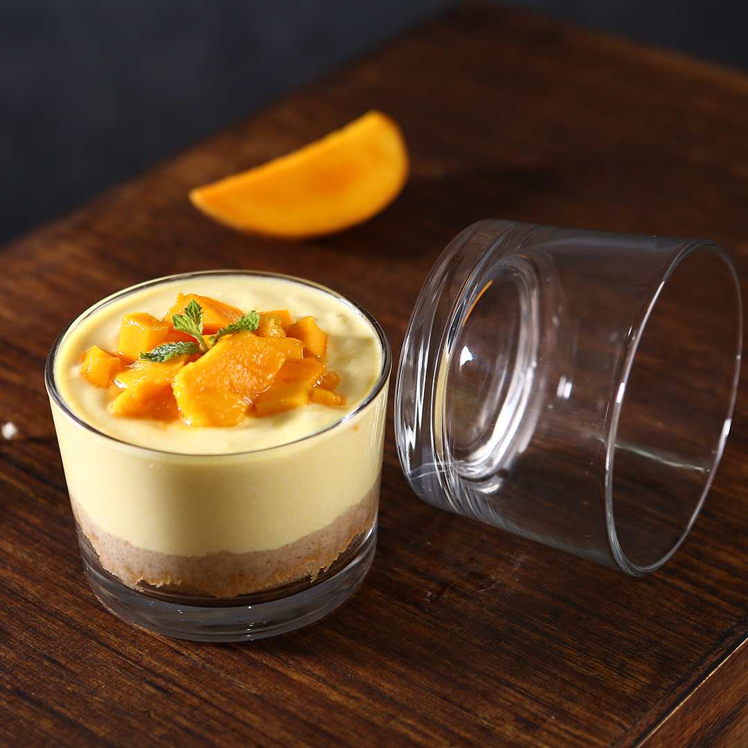 Grande glass dessert bowl filled with pudding and fruit topping.